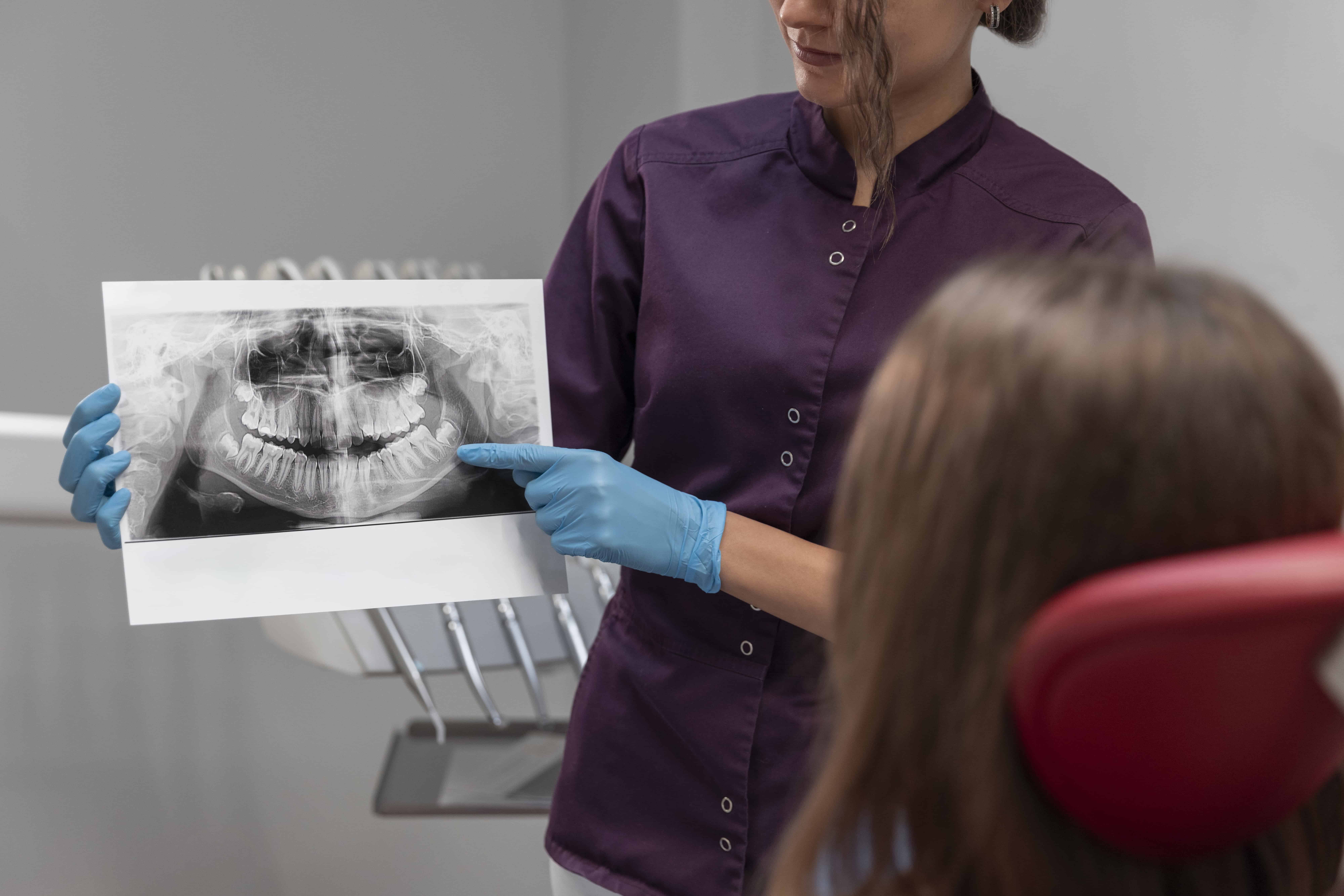 A dentist doctor is doing bone grafting of a women . She is her patient