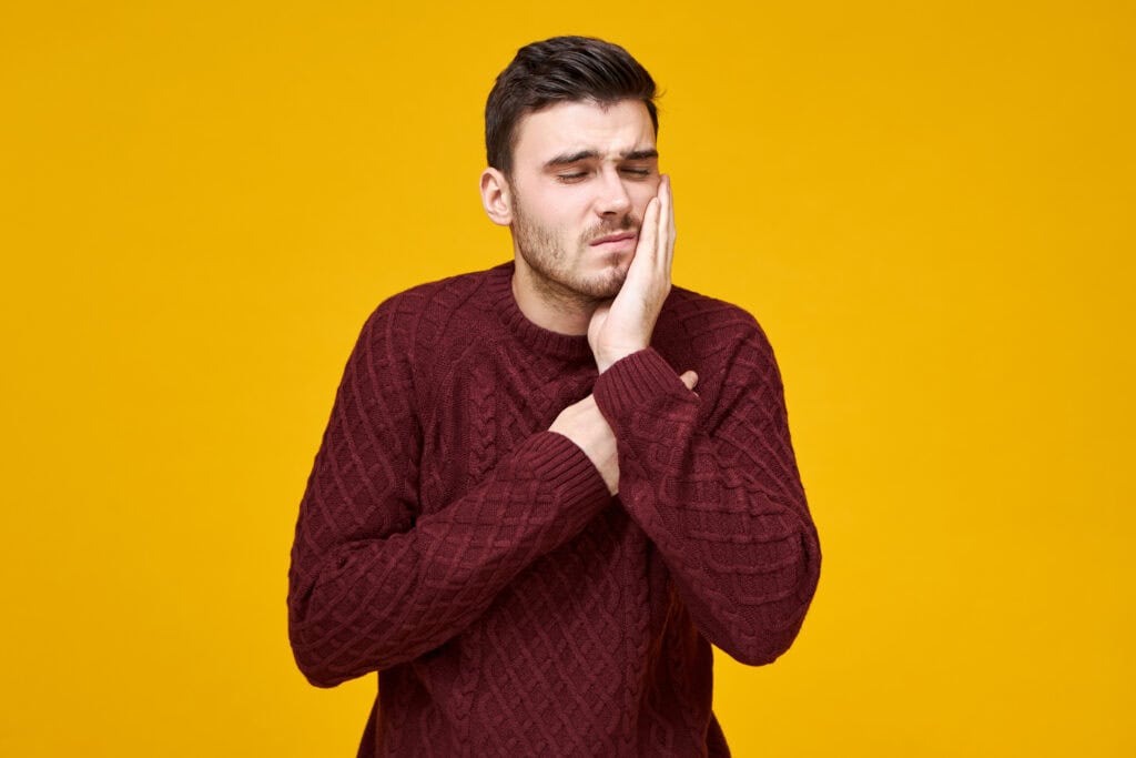 a person facing wisdom teeth pain in dental office