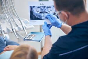 Oral surgeon reviewing training and credentials with a patient